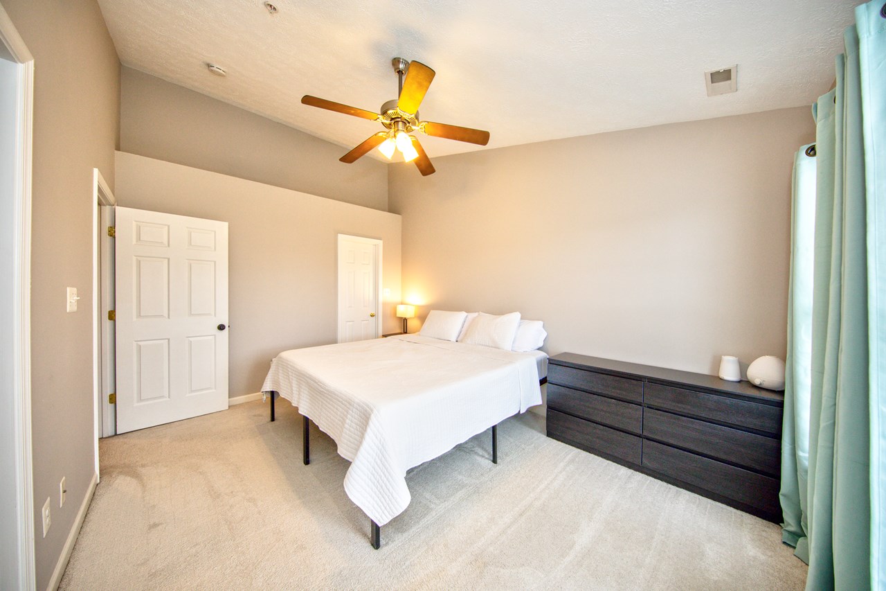 primary bedroom with vaulted ceiling  & fan