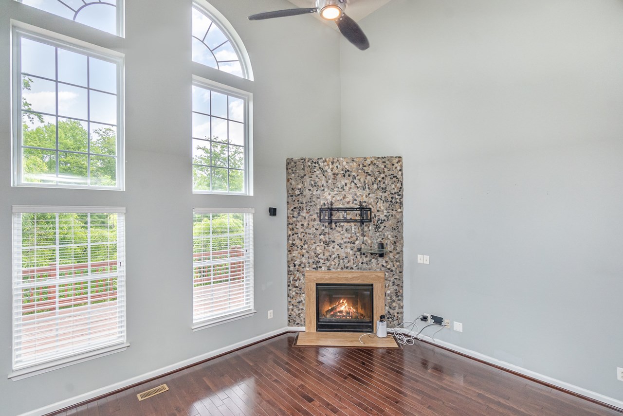 living room with gas fireplace, wall of windows
