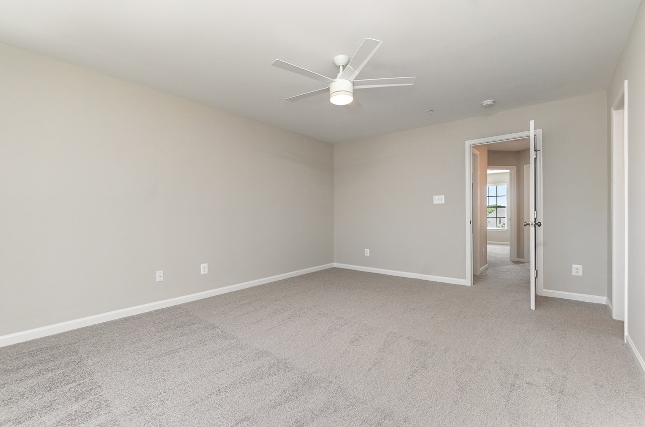 primary bedroom with walk in closet & fan