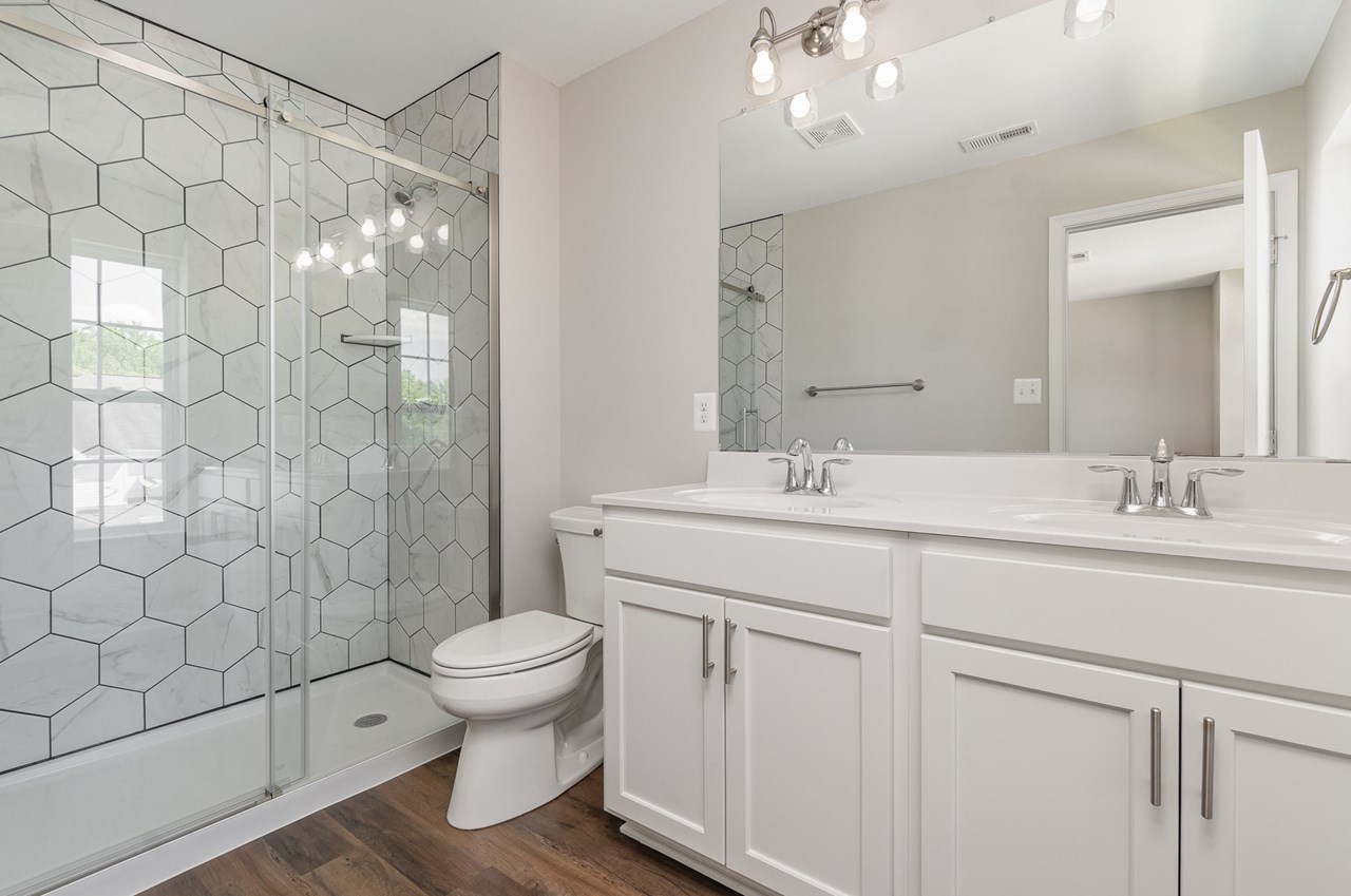 primary bathroom with double sink & decorative shower
