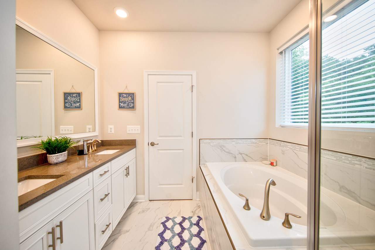 primary bathroom with dual sink, soaking tub & shower