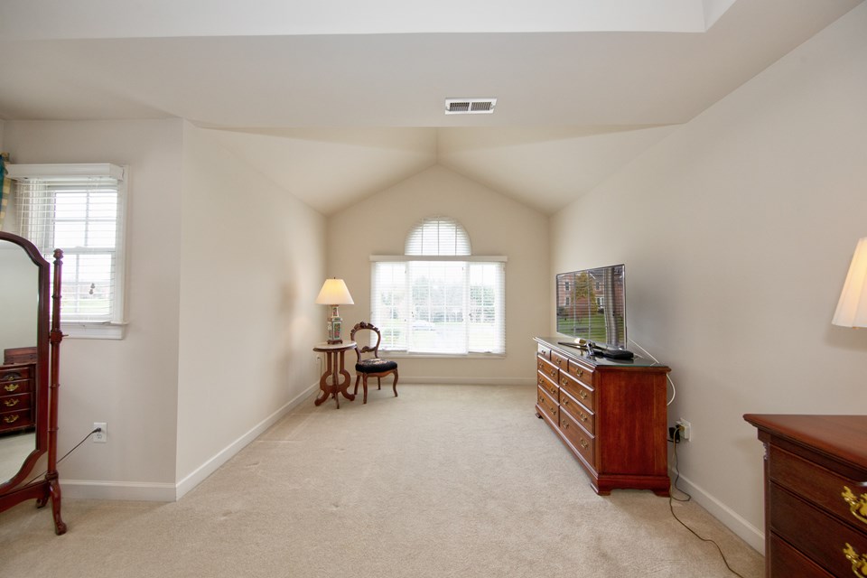 primary bedroom with vaulted ceiling & sitting room