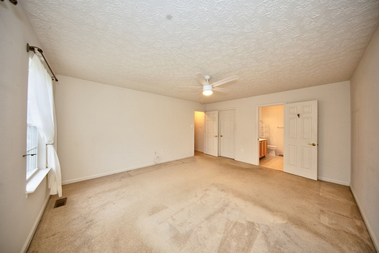 primary bedroom with ceiling fan & walk in closet