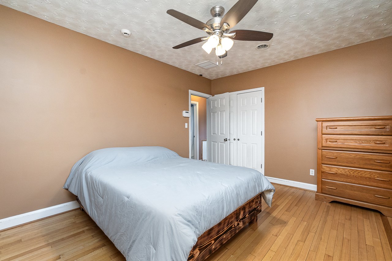 primary bedroom w/ wood floors