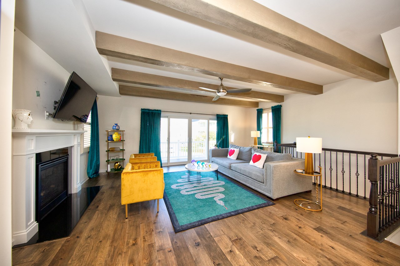 living room w/ hdwd floors & exposed wood beams