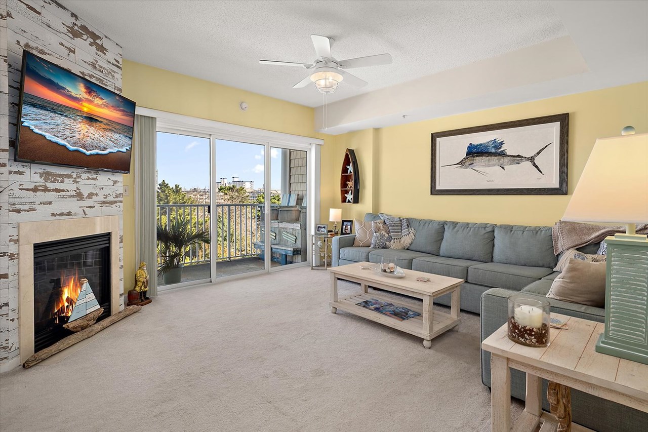 living room with gas fireplace & sliders to balcony