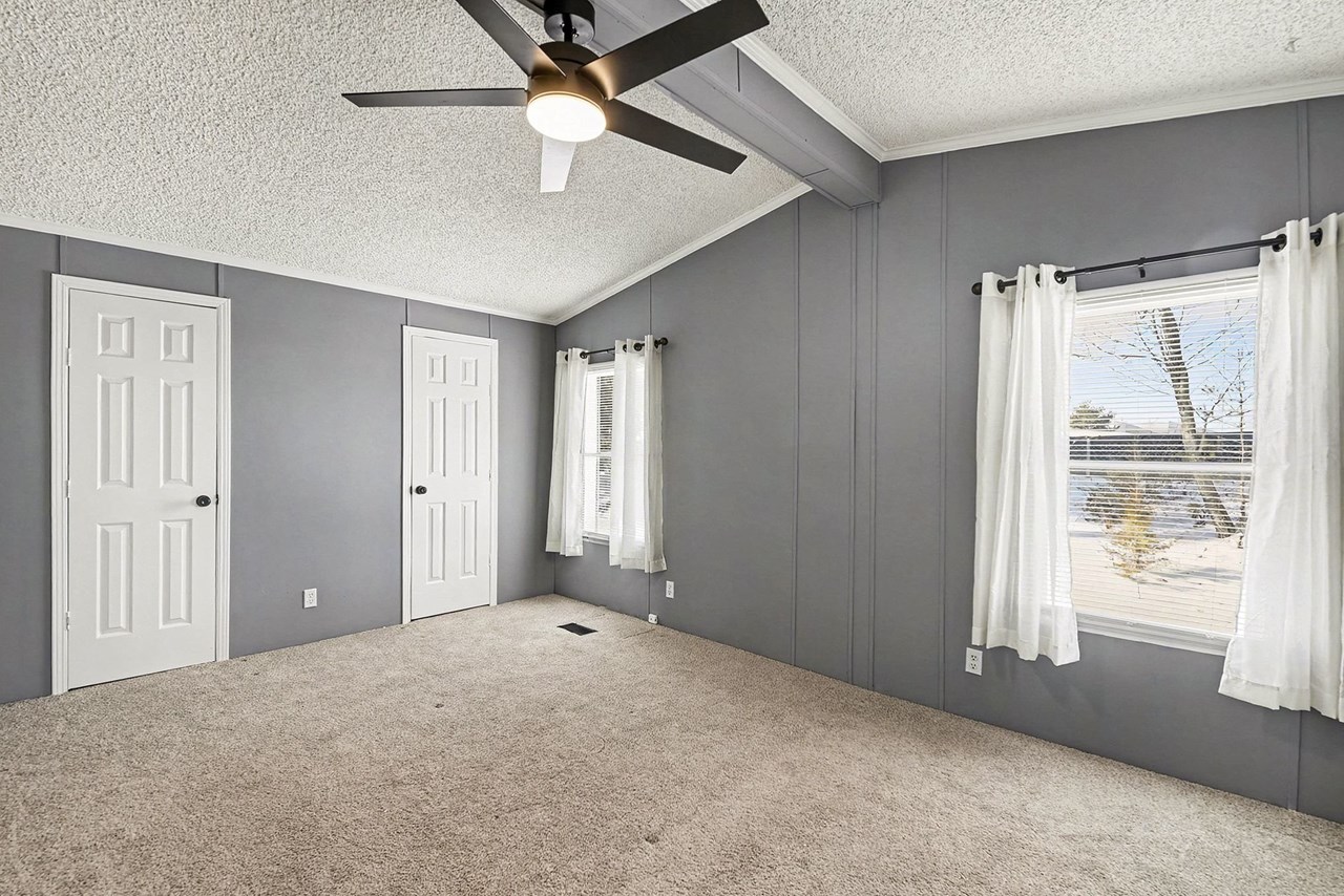 primary bathroom with vaulted ceiling & fan