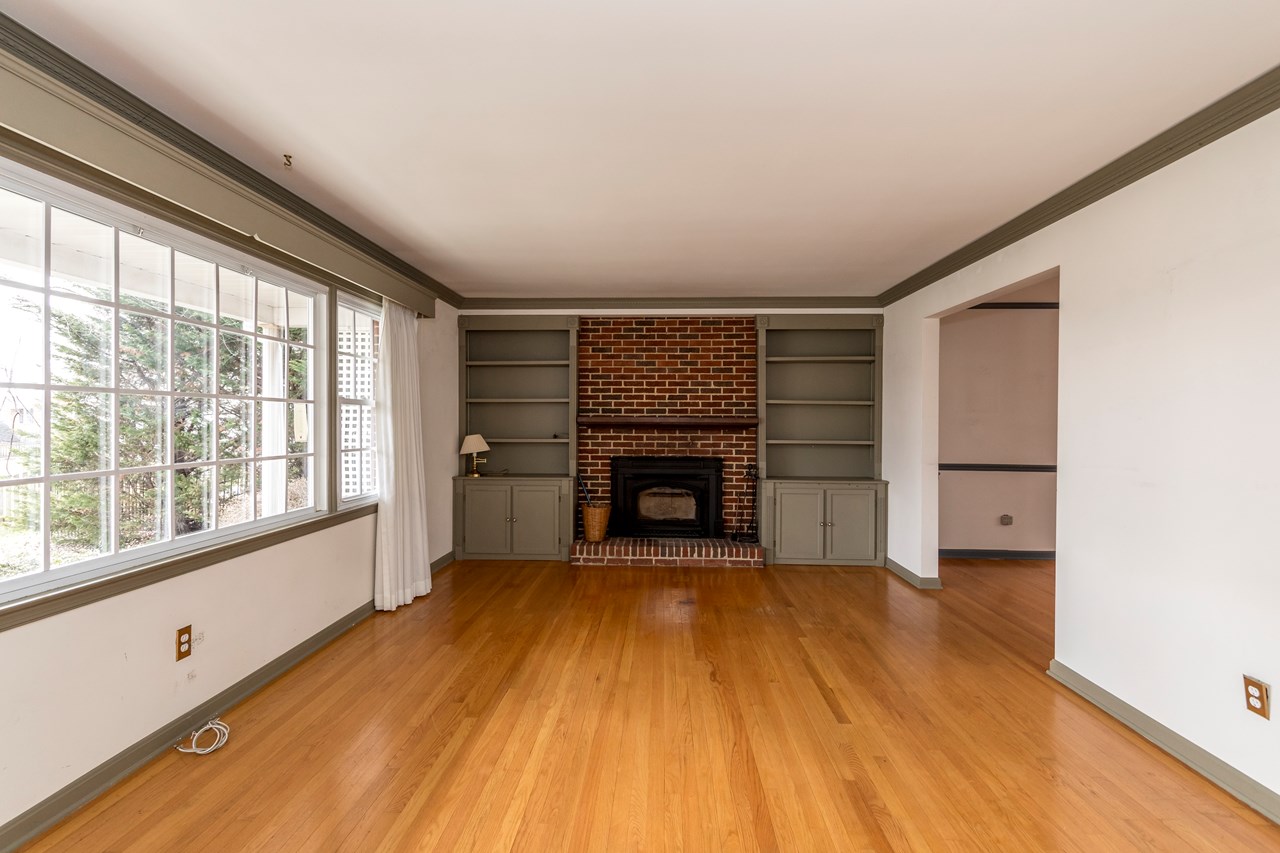 large living room with  custom built in shelves & fireplace
