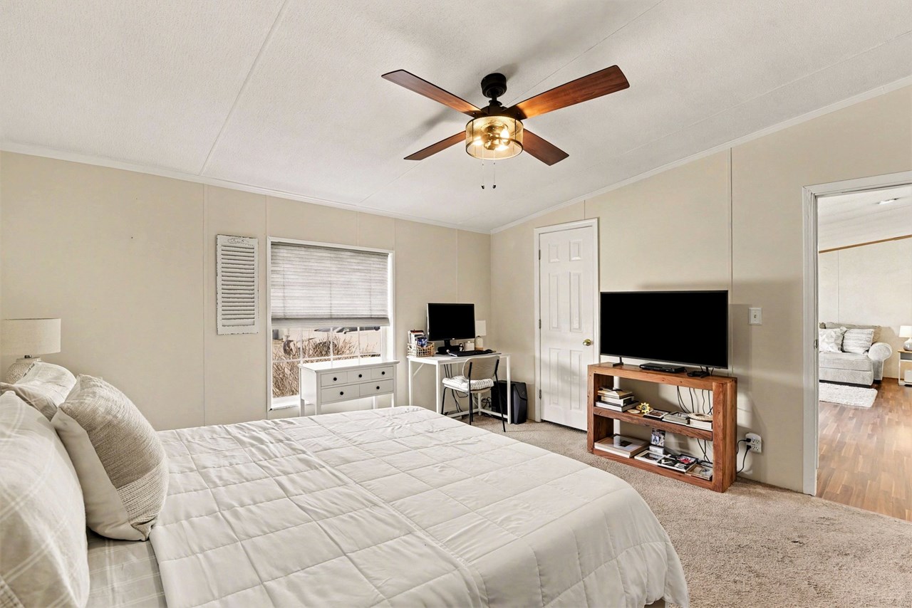 primary bedroom with ceiling fan & full bathroom