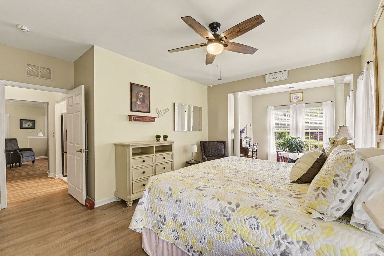 primary bedroom with ceiling fan & full bath
