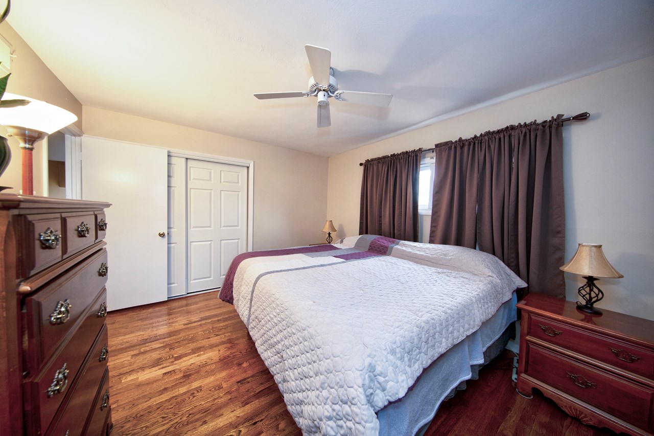 primary bedroom with double closet & ceiling fan